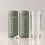 Two bottles of Anagen for Her side by side beside a glass of water