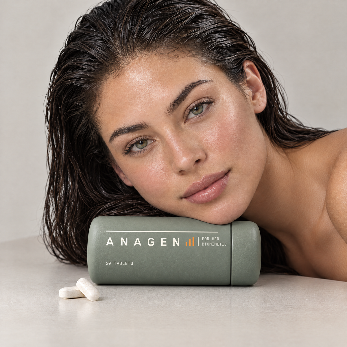 Woman with long wet dark hair resting her head on a bottle of Anagen for Her