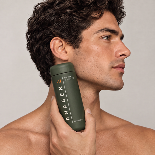 Man with thick dark hair holding Anagen for Him against his jaw
