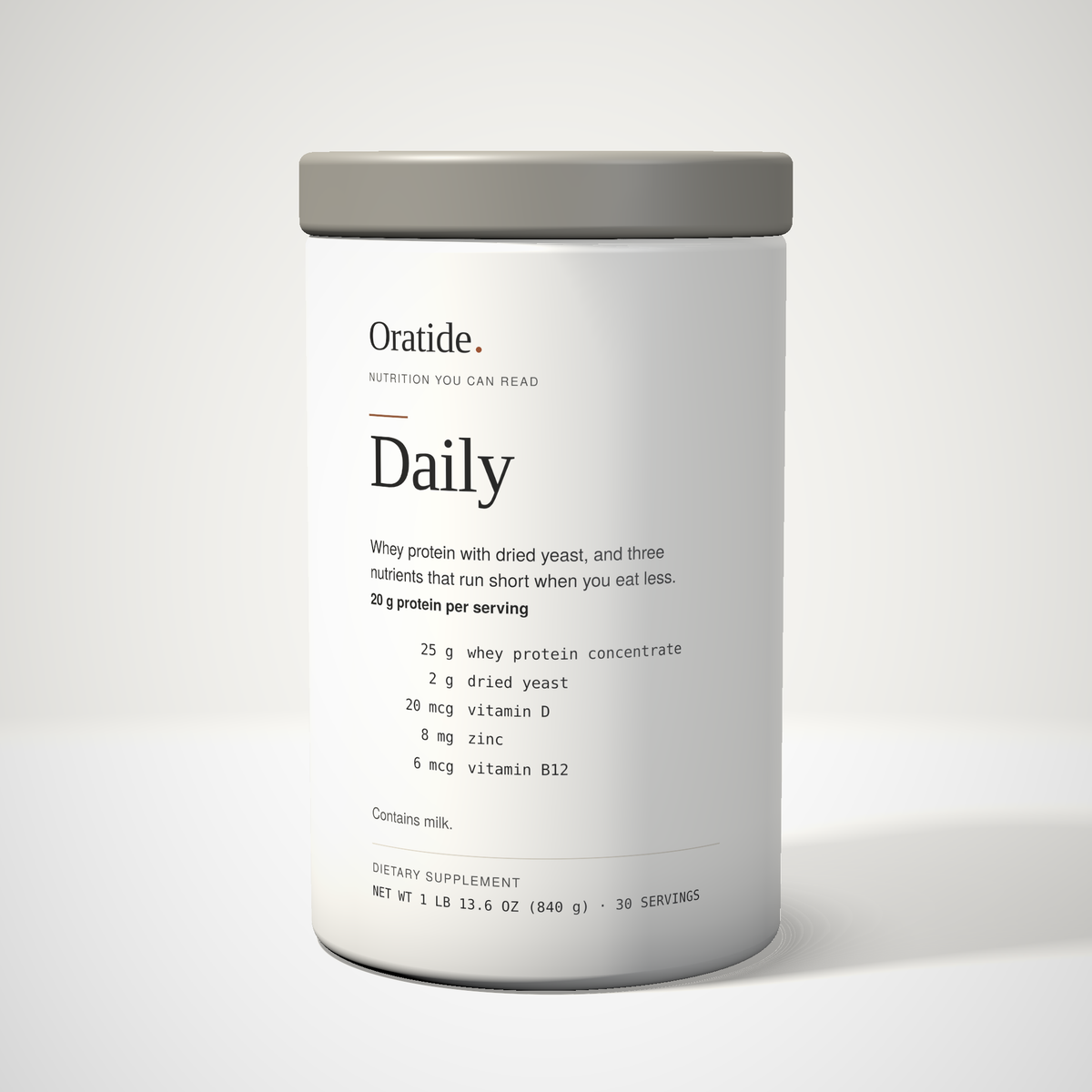 Oratide Daily, a cream 840 g canister with a grey lid, turned slightly and lit from the left on a pale surface.